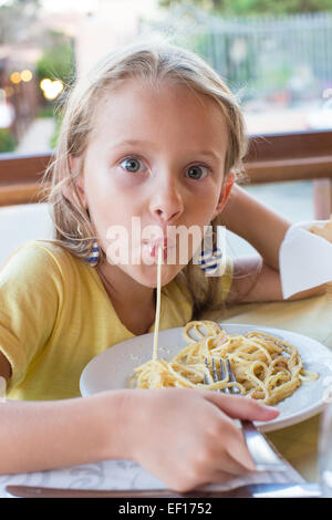 Entzückende kleine Mädchen Spaghetti-Essen im Restaurant im freien Stockfoto