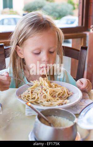 Entzückende kleine Mädchen Spaghetti-Essen im Restaurant im freien Stockfoto