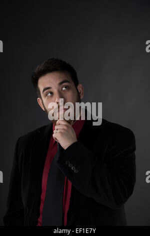 Nachdenklichen jungen Geschäftsmann nachschlagen Stockfoto