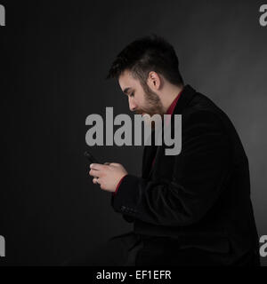 Mann in formelle Kleidung mit Handy in der Seitenansicht Stockfoto