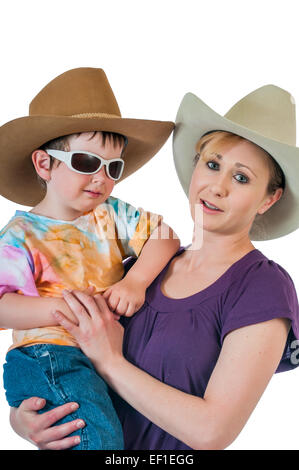 Hübsches junges Cowgirl hält ihre kleine Cowboy. Isoliert auf einem weißen Hintergrund. Stockfoto