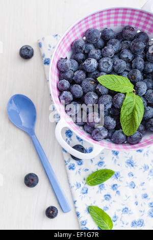 Frische Heidelbeeren in einem Kunststoff-Sieb mit einem Löffel Stockfoto