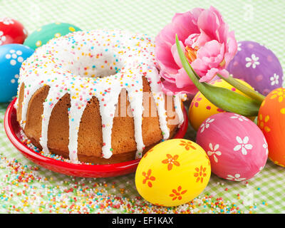 Osterkuchen, Tulpe und bunten Eiern auf Küchentisch Stockfoto