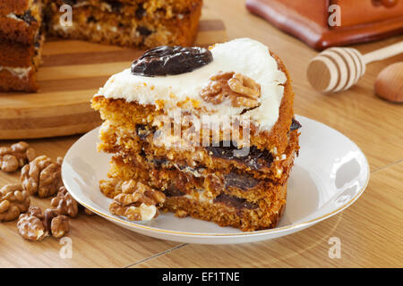 Stück von Honigkuchen mit Pflaume und Nussbaum am Küchentisch Stockfoto