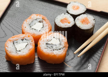 Sushi von Räucherlachs und Philadelphia Käse und Maki mit Stäbchen Stockfoto