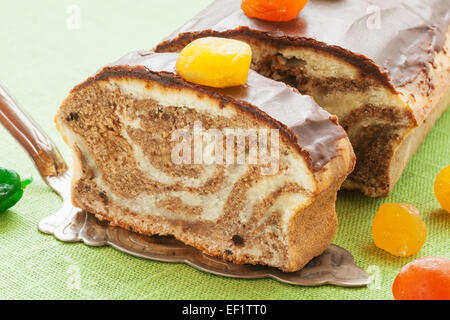 Marmor-lbs-Kuchen mit Schokoladenglasur und karamellisierten Früchten auf Küchentisch Stockfoto