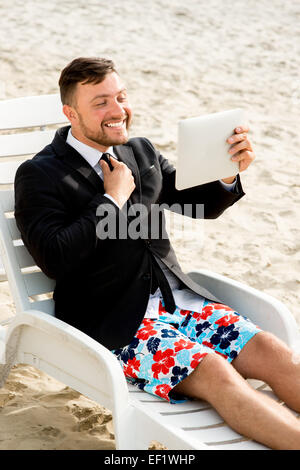 Geschäftsmann Selfie Aufnahme mit digital-Tablette auf dem Liegestuhl am Strand sitzen Stockfoto