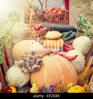 Geerntete Obst und Gemüse in Holzkarren, herbstliche Stillleben. Stockfoto