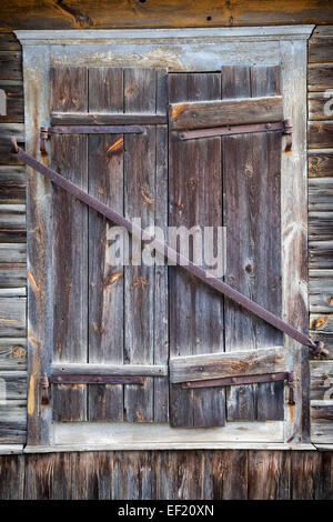 rustikale Fenster des alten Holzhauses geschlossen Stockfoto