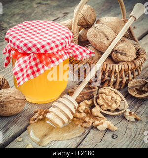 Honig im Glas, Nussbaum in Korb und hölzernen Wagen auf alten Küchentisch Stockfoto