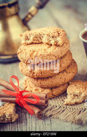 Hausgemachtes Hafer-Kekse, Zimtstangen und Kaffee auf alten Tisch Stockfoto