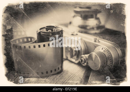 Alte Foto Film Roll und Retro-Kamera auf Schreibtisch. Vintage stilisierte Foto. Stockfoto