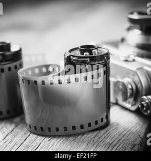 Alte Foto Film Kassette und Retro-Kamera auf Hintergrund. Vintage schwarze und weiße stilisiert. Stockfoto