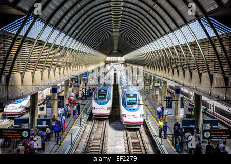 Passagiere und Züge am Bahnhof Santa Justa in Sevilla, Spanien. Stockfoto