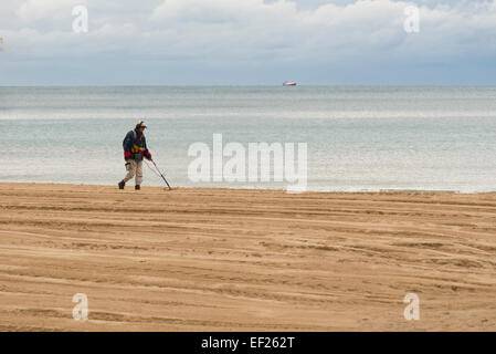 BENIDORM, Spanien – 19. Januar 2015: Ein Mann mit einem Metalldetektor nach dem verlorenen Schatz auf der Beac von Benidorm, Spanien suchen Stockfoto