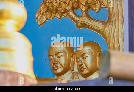 Zwei goldene Buddha Gesichter geschnitzt auf Battersea Park Peace Pagoda London England Europa Stockfoto