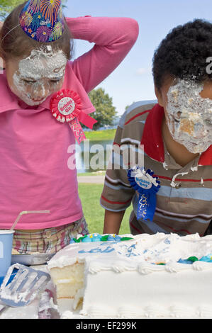 Kinder mit Zuckerguss auf ihren Gesichtern Stockfoto