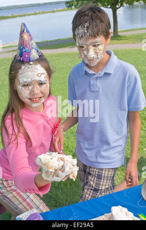 Kinder mit Zuckerguss auf ihren Gesichtern Stockfoto