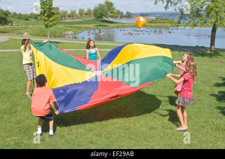 Kinder spielen mit dem Fallschirm Stockfoto