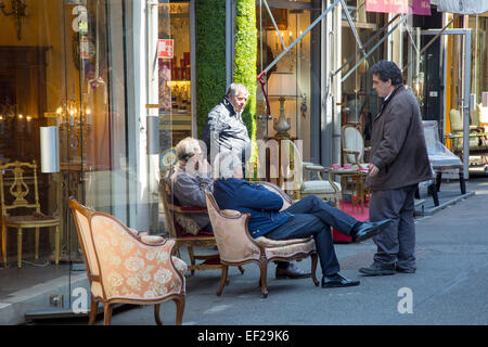 Stall Besitzer Entspannung am Marché Aux Puces de Saint-Ouen, die weltberühmten Flohmarkt, Paris Frankreich Stockfoto