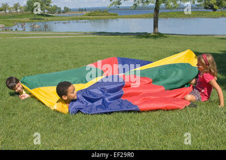 Kinder spielen mit dem Fallschirm Stockfoto