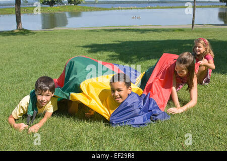 Kinder spielen mit dem Fallschirm Stockfoto