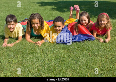 Kinder spielen mit dem Fallschirm Stockfoto