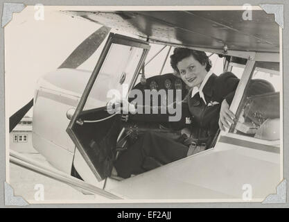 Mitglied der Australian Women Pilots' Association Meg Cornwell im Cockpit der Auster J / 5G Cirrus Autocar Eindecker VH-ADY auf einem Flugplatz, 1954 Stockfoto