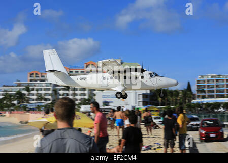 Eine de Havilland Canada Twin Otter sehr niedrig über Maho Beach, Sint Maarten Stockfoto