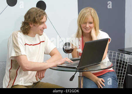 Paar sitzen an einem Tisch, Blick auf Laptop-Computer zusammen Stockfoto