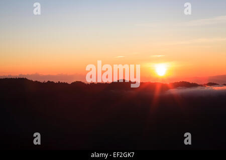 Sonnenaufgang über bewaldete Hänge. DOI Pha Hom Pok Nationalpark. Thailand. Stockfoto
