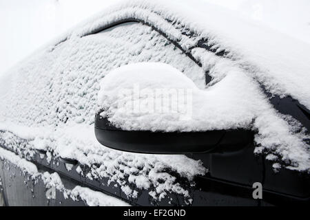 Beschneite Windschutzscheibe von einem dunklen Auto im winter Stockfoto