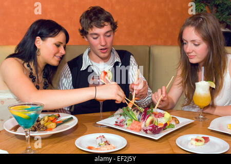 Drei Freunde in einem Sushirestaurant Stockfoto