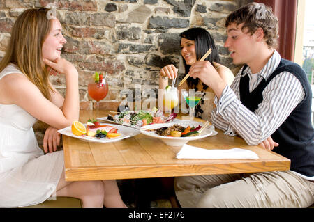 Drei Freunde in einem Sushirestaurant Stockfoto