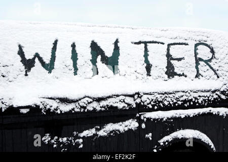 Beschneite Windschutzscheibe von einem dunklen Auto im winter Stockfoto