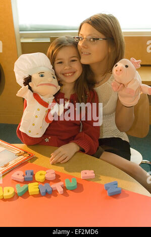 Frau und junge Mädchen spielen mit Puppen Stockfoto