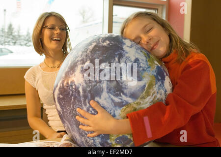 Frau und junge Mädchen mit einem Globus Stockfoto