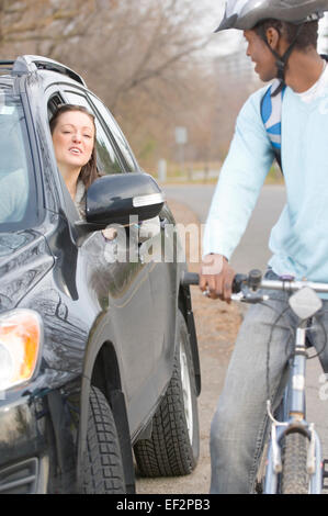 Frau im Auto, im Gespräch mit Radfahrer Stockfoto