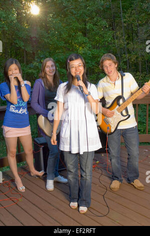 Vier Freunde spielen in einer Band auf einer Außenterrasse Stockfoto