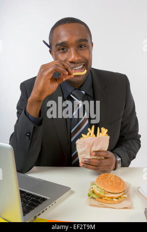 Kaufmann Essen an seinem Schreibtisch Stockfoto