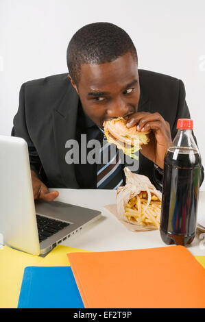 Kaufmann Essen an seinem Schreibtisch Stockfoto