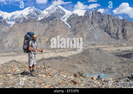 Junge Wanderer mit großen Rucksack auf Engilchek Gletscher mit malerischen Tian Shan-Gebirge in Kirgisistan Stockfoto