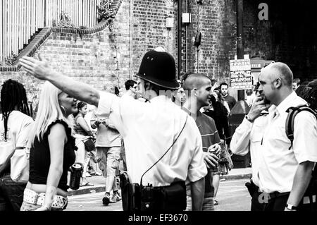 LONDON, UK - 28. August 2005: bei Notting Hill Carnival Polizist mit seinem Arm oben zeigt Richtung, Mitglied der Öffentlichkeit. Stockfoto