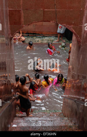 Menschen, die ein Bad in einer heißen Quelle, die geglaubt wird, um heilende Qualitäten haben, in Lakshmi Narayan Tempel-Komplex in Rajgir, Bihar, Indien. Stockfoto