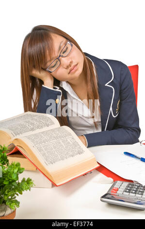 Müde Teenager-Studentin sitzt an ihrem Schreibtisch Stockfoto