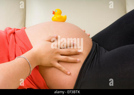 Gummiente auf einer schwangeren Bauch Stockfoto