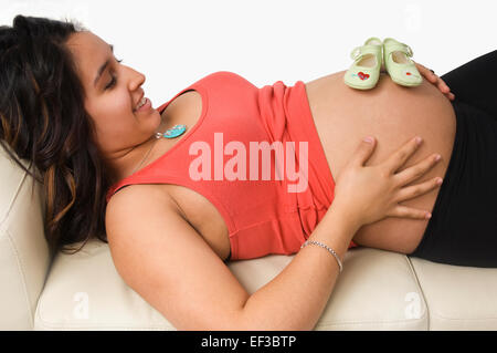 Baby-Schuhe auf schwangere Frau Bauch Stockfoto