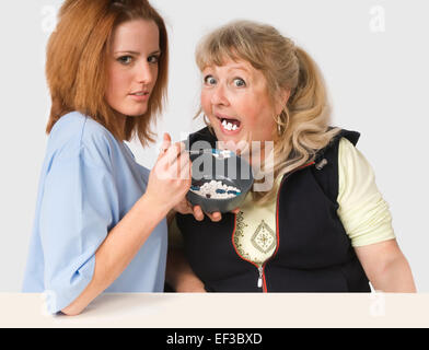 Krankenschwester, die Verfütterung von Pillen an Patienten Stockfoto