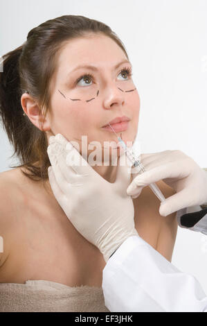 Arzt Patienten eine Nadel auf ihrem Gesicht geben Stockfoto