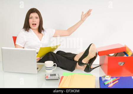 Geschäftsfrau, die mit ihren Füßen auf Schreibtisch sitzen Stockfoto